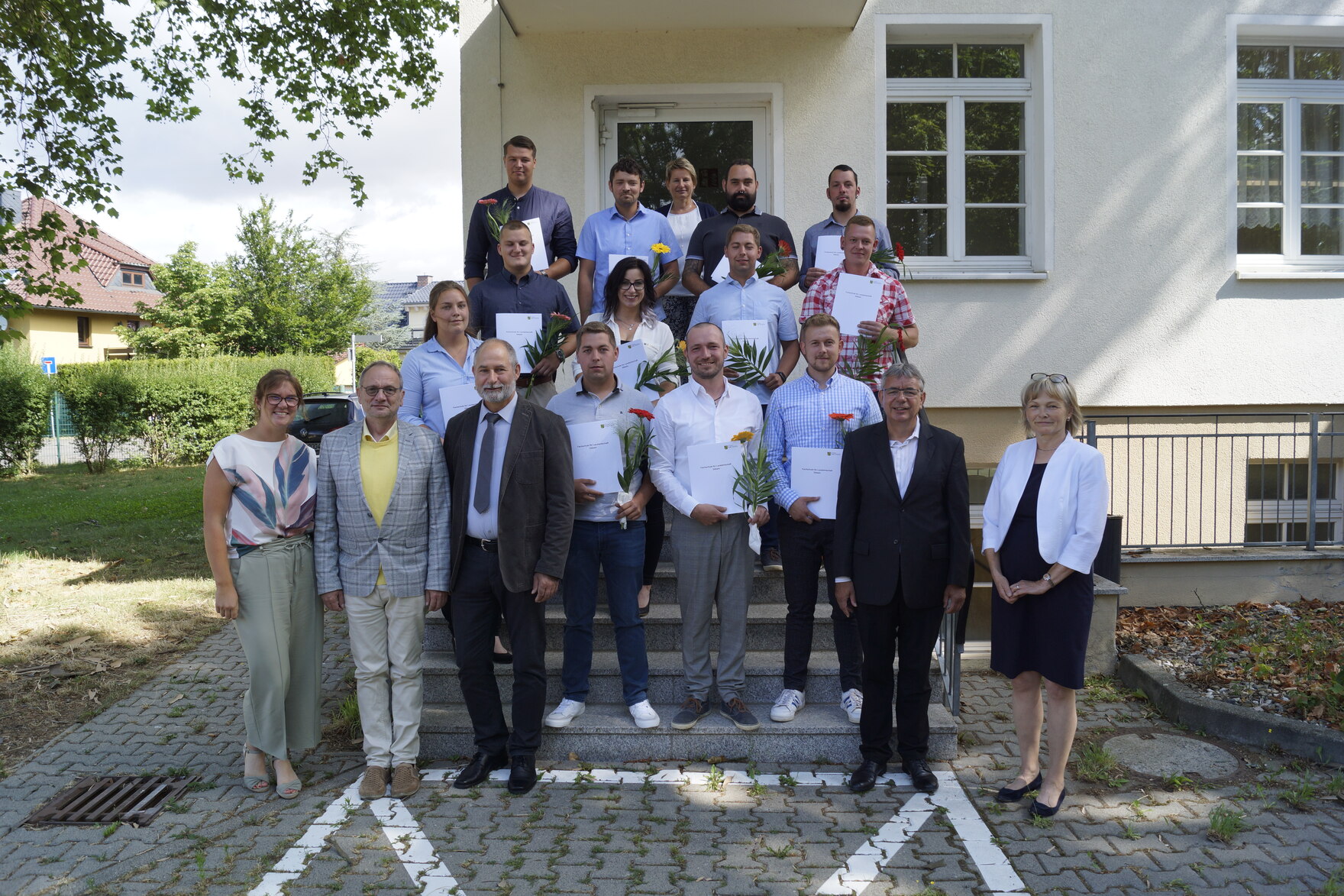 12 Absolventinnen und Absolventen vor der Fachschule für Landwirtschaft in Döbeln