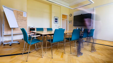Seminarraum mit Tischen, Stühlen, Tafel, Flipchart
