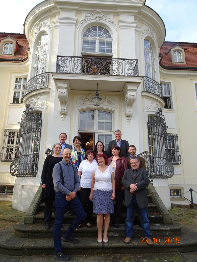Gruppenbild mit elf Personen vor dem Barockschloss Reinhardtsgrimma